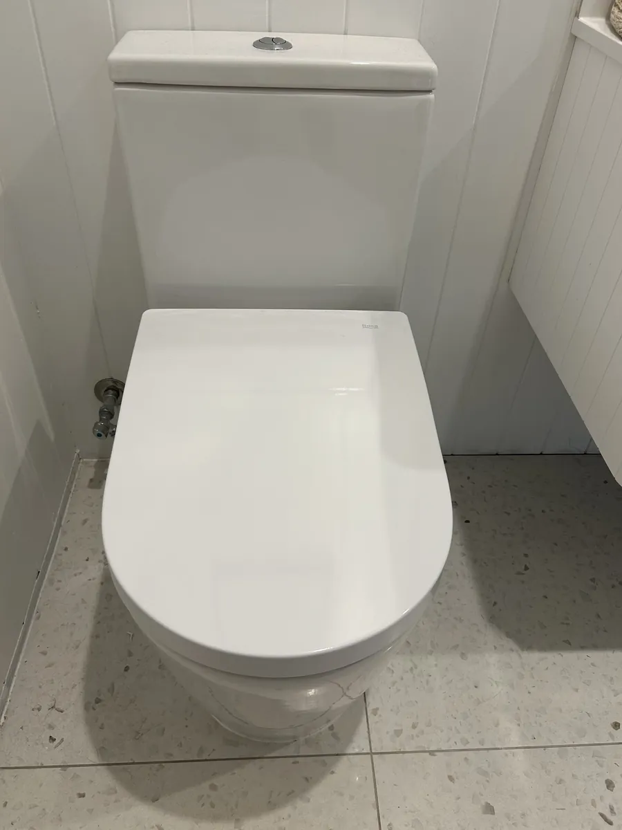 New close-coupled toilet installed in a white bathroom